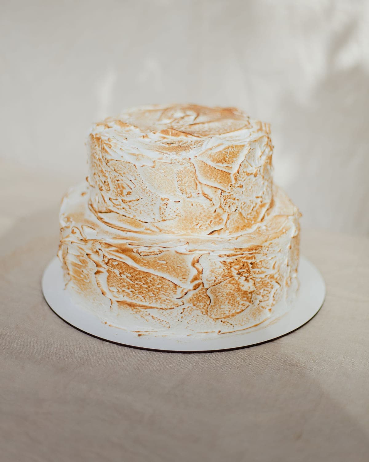 Two-tier ivory cake with a soft toasted meringue finish